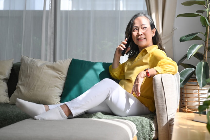 Attractive mature lady relaxing on comfortable couch and talking